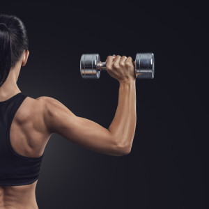 Fitness woman in training muscles of the back with dumbbells